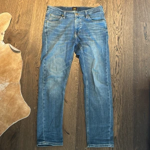 Blå Lee jeans  - Säljer ett par blå jeans från Lee med raka ben. Jeansen har en snygg tvätt och är knappt använda. W31 L30