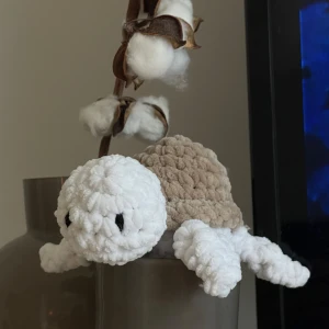 Virkad sköldpadda - En virkad sköldpadda i mjukt garn, med vit kropp och beige skal. Lokalt inköpta garner och verktyg, helt handgjord av mig. Perfekt för dig som gillar söta gosedjur och unika dekorationer 🤎 Storlek: 16x14cm