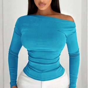 Turkos offshoulder långärmad topp - Snygg turkos långärmad topp med offshoulder-design och tight passform. Toppen har en slät yta och sitter figurnära, perfekt för dig som gillar en stilren och modern look. Materialet är stretchigt och följsamt, vilket gör den extra bekväm.