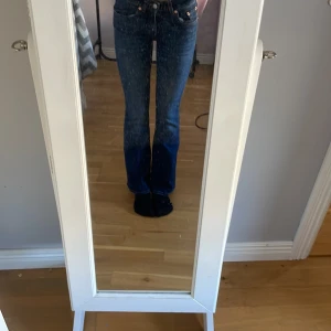 Blå bootcut jeans 157 XXS short - Snygga blå bootcut jeans från 157 i storlek XXS short. Jeansen har låg midja och klassisk femficksdesign. Tillverkade i jeansmaterial med en schysst tvätt och kontrastsömmar. Perfekta för dig som gillar en tidlös och avslappnad look.