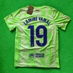 Barcelona Lamine Yamal fotbollströja Nike - Snygg Barcelona fotbollströja med Lamine Yamal och nummer 19 på ryggen. Tröjan är ljusgrön med mönster, har korta ärmar och är tillverkad i lätt polyester. FCB-logga, Nike Swoosh och Spotify-logga på framsidan, UNHCR ACNUR tryck på ryggen. Perfekt för dig som älskar Barca!