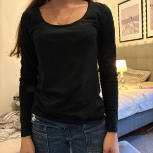 Svart långärmad tröja från H&M - Enkel och stilren svart långärmad tröja från H&M i storlek S. Tröjan har rund halsringning och är gjord i mjuk bomull, perfekt att matcha med jeans eller kjol. Snygg baströja som funkar året runt.