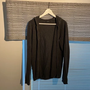 Svart hoodie från Jack & Jones - Mysig svart hoodie från Jack & Jones med dragkedja framtill och huva. Perfekt för lager-på-lager och chill dagar. Långärmad och i mjukt material som känns skönt mot huden.