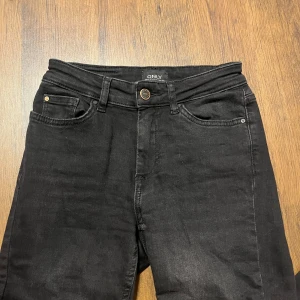 Svarta jeansbyxor från ONLY XS - Svarta jeansbyxor från ONLY i klassisk femficksmodell. Byxorna har bälteshällor, knapp och dragkedja framtill samt raka bakfickor. Snygg, enkel design som passar till allt. Materialet är mjukt och stretchigt jeans. Tvättlappen är avklippt då den kliade. 