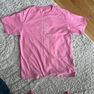 Billie eilish x takashi Murakami T-shirt - Rosa Billie eilish x takashi Murakami T-shirt från uniqlo, de tillverkar inte längre dessa T-shirts tyvärr 💗tröjan har en liten fläck på framsidan men det ör inget man tänker på💕den är gjort i bomull och har en oversized passform, den är i storlek 9-10 år men då den är oversized så passar den mig som är 14 år och 160cm lång💕
