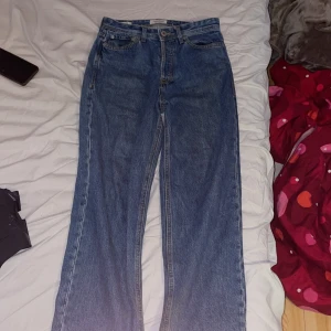Baggy blå jeans från Jack & Jones - Baggy Alex jeans från Jack & Jones i klassisk blå denim. Modellen har hög midja, raka ben och femficksdesign. Snygga kontrastsömmar och en avslappnad, loose fit som ger en cool och trendig vibe. Perfekta för dig som gillar streetstyle och bekväma jeans. De är nästan helt nya riktigt bra skick och de är inte sönder någonstans. 