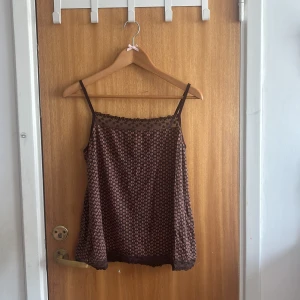Brun blommig linnetopp La Redoute - Supersöt brun linnetopp med små blommor i beige från La Redoute Essentiels. Spaghettiband och mesh med broderade blommor upptill ger en romantisk vibe.💞 Dock!! Har en defekt som sytts ihop vilket man kan se på de två sista bilderna💗
