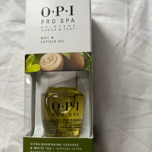 OPI Pro Spa nagel- och nagelbandsolja NY - OPI Pro Spa Nail & Cuticle Oil med cupuaçu och vitt te. Oljan kommer i en genomskinlig glasflaska på 14,8 ml och har en gulaktig ton. Perfekt för att vårda och återfukta nagelband och naglar.