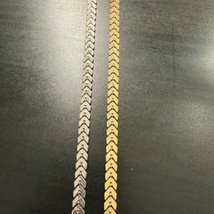 Två fotlänk i guld och silver - Två stilrena fotlänk med pilformade länkar, ett i guld och ett i silver. Båda har justerbar kedja och ger en clean och modern vibe. Perfekta att bära tillsammans eller var för sig för en snygg layering-effekt.