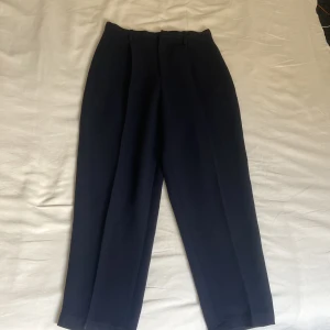 Marinblåa kostymbyxor - Petite - Marinblåa kostymbyxor med hög midja och rak passforme. Byxorna har pressveck framtill. 