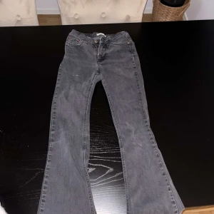 jeans från ginatricot - Svarta lowwaist boocut Jeans från ginatricot i storlek 32, använda flera gånger och är urtvättade, dem var svarta men är nu gråa, dem sitter jättefint och inget fel med dem, lite sliten på låret men inget man tänker på. 