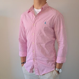 Randig Ralph Lauren Skjorta - Stl S, Slim Fit - Hej säljer en fin Ralph Lauren skjorta I randigt mönster med färgerna rosa och vit, Perfekt till sommaren! 🏖🏝 | Skick: 9/10 |  Stl: S, Slim fit | Han på bilden är 172cm | Fraktar spårbart med Instabox eller Postnord | Mvh Galgen 🤗