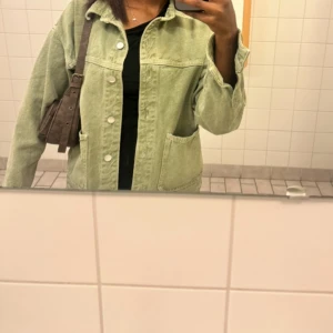 Ljusgrön  jeansjacka -  Skriv för mer info Säljer en ljusgrön oversized jeansjacka med stora fickor framtill och vita knappar. Jackan har klassisk krage och är långärmad, perfekt för dig som gillar en chill och avslappnad stil. Passar till allt och är superenkel att styla.