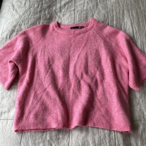 Rosa stickad tröja från 157, XS - Superfin rosa stickad tröja från 157 i storlek XS. Tröjan har korta ärmar, rund halsringning och ribbade kanter. Perfekt för lager-på-lager och ger en mysig vibe till din outfit. 