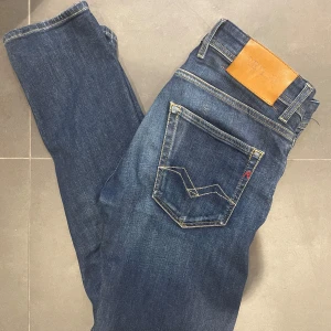 Blå Replay jeans  - Snygga blå jeans från Replay i ekologisk bomull. Klassisk femficksmodell med raka ben och kontrastsömmar. Bakfickorna har Replay-logga och coola detaljer. Perfekta för dig som gillar stilrena och bekväma jeans.