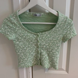 Grön blommig croppad topp New Yorker - Grön topp storlek xxs från new yorker. Bra skick. 50kr