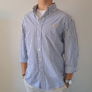 Randig Ralph Lauren Skjorta - Stl L, Slim Fit - Hej säljer en fin Ralph Lauren skjorta I randit mönster med färgerna blå och vit, Perfekt till sommaren! 🏖🏝 | Skick: 9/10 | Stl: L, Slim fit | Han på bilden är 172cm, men passar längre | Fraktar spårbart med Instabox eller Postnord | Mvh Galgen 🤗