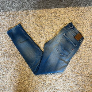 Replay Anbass hyperflex blå jeans herr - Snygga Replay Anbass jeans i klassisk blå tvätt med lätt slitning och smal passform. Jeansen har fem fickor, läderpatch bak och tydliga Replay-detaljer. Perfekta för dig som gillar en modern och stilren look. Storlek 31 men mått kan såklart skickas vid osäkerhet. Postas antigen samma dag som köp eller dagen därpå🙌💯