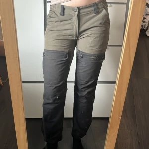 Grönsvarta fodrade fritidsbyxor från High Mountain  - Grönsvarta fodrade fritidsbyxor från High Mountain! Byxorna har flera fickor, elastisk midja och förstärkta partier på knän och bak. Perfekta för uteliv eller äventyr. Materialet är slitstarkt och känns bekvämt mot huden. Använda fåtal gånger! Storlek 36💚