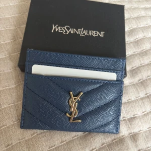Blå YSL Korthållare - Säljer en snygg lyxig YSL korthållare för ett bra pris, skicket är 10/10. Kontakta mig vid frågor!🤙