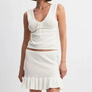 Vit ribbad linnetopp från NA-KD - Superfin vit linnetopp från NA-KD med v-ringning och knyt framtill. Den är i storlek M, men har blivit avsiktligt ”töjd” för att passa bättre, så uppskattar nog att den är närmare L.