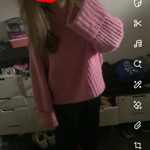 Rosa stickad tröja med vida ärmar - Supermysig rosa stickad tröja med breda ribbade detaljer och långa, vida ärmar. Perfekt för att hålla sig varm och ändå se snygg ut. Passar dig som gillar en loose och chill stil.