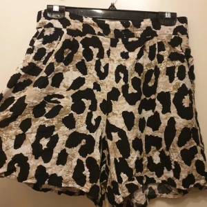 Leopardmönstrade shorts Pernilla Wahlgren - Snygga shorts från Pernilla Wahlgren med leopardmönster i svart, beige och brunt. Modellen är loose fit med hög midja och tillverkad i ett lätt tyg som passar perfekt för varma dagar. Supersköna, står 40 i men de är som M skulle jag nog säga. 