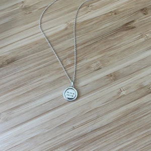 Silverfärgat halsband med rund berlock som går att vrida på - Snyggt halsband i silverfärg med tunn kedja och rund berlock. Ena sidan av berlocken har texten 'You are my sunshine' och andra sidan har en liten stjärndesign. Berlocken går att vrida på för att ändra sidan för den design man känner för!! Så gulligt och stilrent halsband i äkta sterling silver!! Halsbandet har några knutar på sig som jag inte får upp så därför säljer jag billigt men de märks inte av!!💗💗