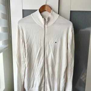 J.Lindeberg hel zip up kofta - En sällsynt och mycket fin tröja med full zip Storlek XL på lappen men sitter exakt som en L ska göra, därför väljer jag att lägga storlek L i annonsen Hel vit med en svart logga Skicka meddelande vid några funderingar Kolla gärna även in mina andra annonser