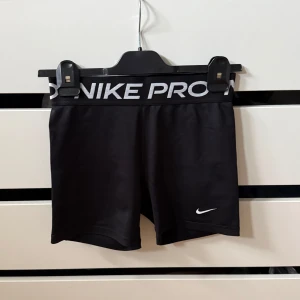 Nike Pro shorts - Svarta Nike Pro shorts och bred resår med logga. Bortsklippt lapp men det är antingen storlek 170 eller xs