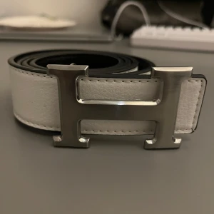 H-Bälte - Vit med silver H. Nytt skick. 110 CM