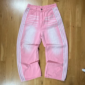 Rosa baggy jeans med vita ränder - True adidas b@lenciaga jeans. 10/10 skick. Mer information, bilder och prisdiskutering i dm. 