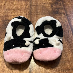 Mjuka tofflor med ko-motiv - Aldrig använda!!, storlek 36/37 Supergulliga och fluffiga tofflor i svartvitt ko-mönster med rosa nos och små horn.