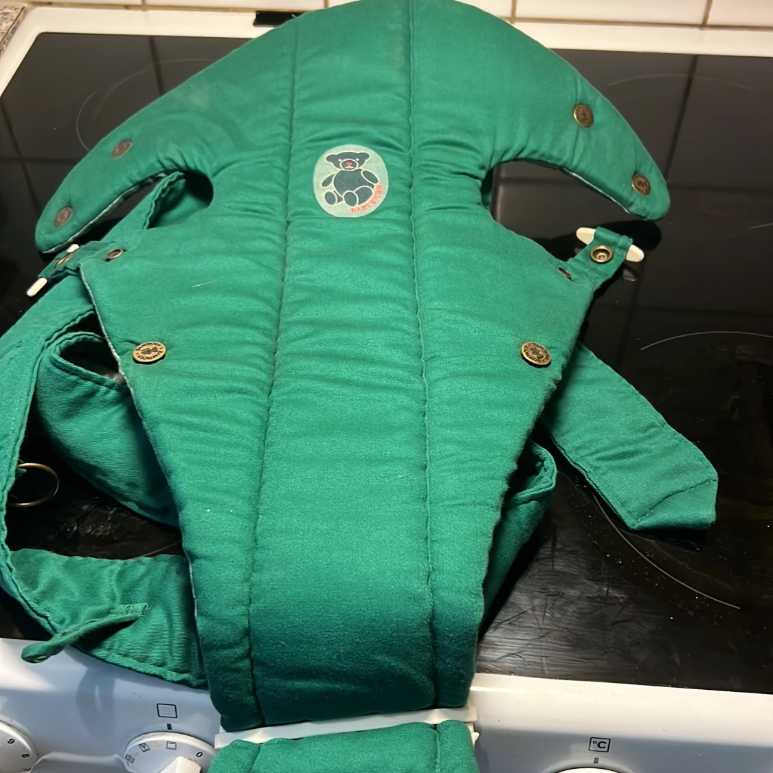 Grön bärsele med nallebrodyr babybjörn