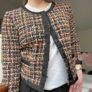 Trekvartsärmad rutig kavaj - Snygg trekvartsärmad flerfärgad rutig kavaj/jacka med svarta detaljer och knappar. Perfekt för att ge en färgglad touch till din outfit. 