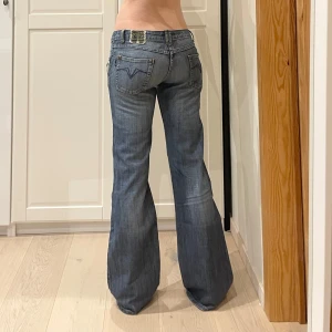 Lågmidjade bootcut jeans💕 - Snygga blå bootcut jeans med coola detaljer på bakfickorna. De har en låg midja och en klassisk femficksdesign. Perfekta för en avslappnad stil med en touch av attityd.