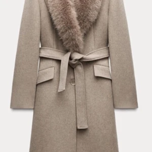 Beige kappa med pälsdetalj - Elegant beige kappa med en lyxig pälsdetalj vid kragen som är avtagbar.🧸