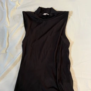 Svart ärmlös topp från newyorker - Säljer även denna svarta ribbade och ärmlösa toppen från new yorker. Hög krage och lång i längden. Storlek L men passar som en S/M