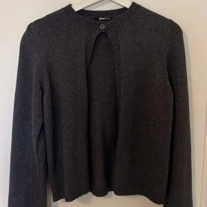 Mörkgrå kofta från Gina Tricot - Säljer en stilren mörkgrå kofta från Gina Tricot. Koftan har en enkel knappdetalj vid halsen och är perfekt för lager-på-lager. Den har långa ärmar och en klassisk passform som passar till många olika outfits❣️ endast använd några få gånger