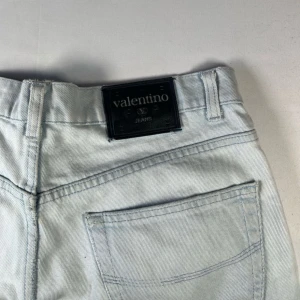 Ljusblå jeans från Valentino - Snygga ljusblå jeans från Valentino med en klassisk femficksdesign. De har en diskret slitning på framsidan och en knappgylf. Perfekta för en avslappnad stil.
