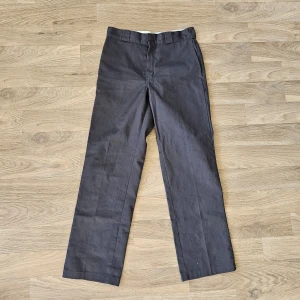 Grå byxor från Dickies - Snygga grå byxor från Dickies, modell 874 Original Fit. De har en klassisk design med raka ben och en normal passform. Perfekta för en stilren look.
