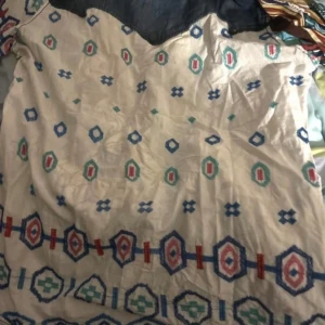 Mönstrad klänning med fickor - Säljer en unik skjorta med färgglada mönster i blått, rött och grönt. Skjortan har två bröstfickor med knappar och en mix av geometriska och blommiga mönster. Perfekt för dig som vill sticka ut!