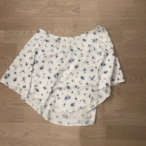 Vit blommig kjol - Säljer en söt vit kjol med blommigt mönster i blått och rosa. Perfekt för en sommaren! Ska flytta snart så vill gärna bli av med allt så fort som möjligt (pris kan diskuteras)💕