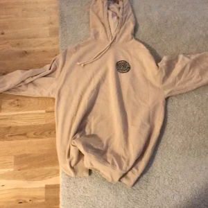 Beige SpongeBob hoodie - Säljer en beige hoodie med SpongeBob SquarePants-tryck. Den har en stor luva och ett tryck på både framsidan och baksidan. Perfekt för alla SpongeBob-fans!