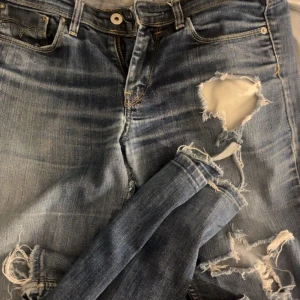Blå slitna Levis jeans - Säljer ett par blå Levis jeans med slitningar på knäna och låren. Köpta här på plick, men har inte använts jätte mycket sen dess. Passar bra och är i bra skick förutom nere vid fötterna där det är lite slitet, bild på det finns. Hör av dig om du har någon fråga 💕