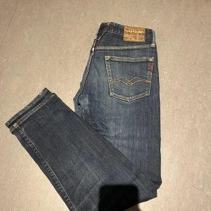 Mörkblå jeans från Replay - Snygga mörkblå jeans från Replay med klassisk femficksdesign och diskreta sömmar. Jeansen har en normal passform och är perfekta för en avslappnad stil. De har en knappgylf och är tillverkade i slitstarkt denim. Pris kan diskuteras vid snabb affär. Storlek 31/32