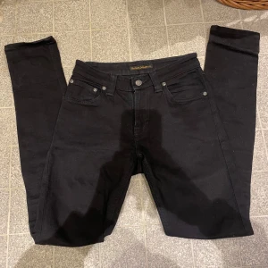 Svarta jeans från Nudie Jeans - Säljer mina älskade svarta nudie jeans som är skiny fit som är perfekt för en modernare look. Jag köpte jeansen nu i vintras men var lite små så låter dom går vidare❤️ skriv till mig vid intresse ❤️❤️❤️❤️❤️storlek 25w 32L