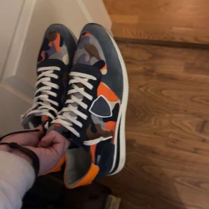 Camouflage sneakers med orange detaljer - Tjenare! Säljer ett par philipe model trpz ett par riktigt bekväm dojjor väldigt fint skick lite smutsiga men inga defekter storlek 44 passar 43 med ny pris:3499 mitt pris:1999 pris kan diskuteras tar gärna byten 