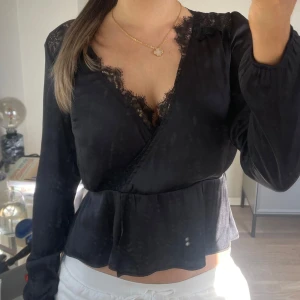 Jättesnygg svart omlottblus med spets! - Jättesnygg svart omlottblus i satin med tajt midja💗