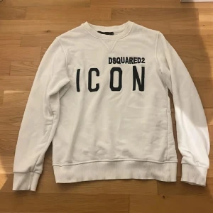 vit sweatshirt från Dsquared2 - Säljer en snygg vit sweatshirt från Dsquared2 (äkta) orginal pris 3200kr .Tröjan har långa ärmar och en klassisk rund halsringning. Perfekt för en casual look. Säljer denna då den har blivit för liten för mig.